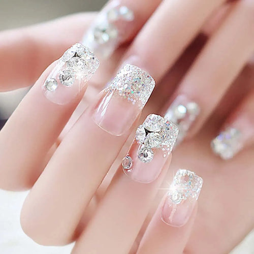 Nails with glittery diamond decorations on a neutral background