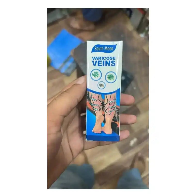 Hand holding a South Moon Varicose Veins product packaging against a blurred background
