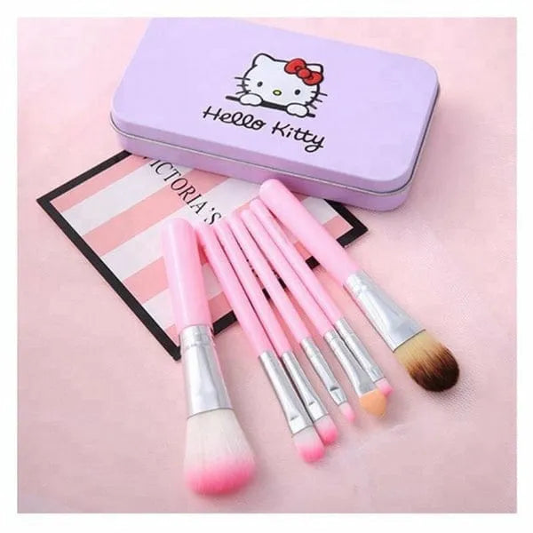 Set of makeup brushes with pink bristles in a Hello Kitty-themed case on a pink background.