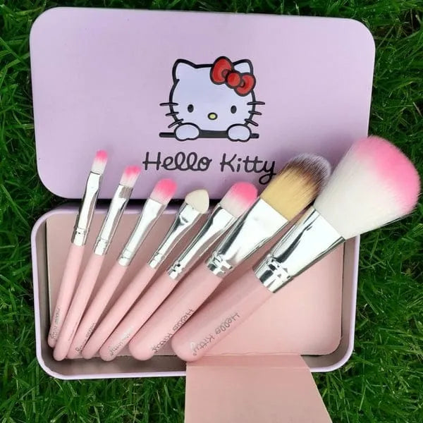 Set of Hello Kitty-themed makeup brushes in a pink case on grass