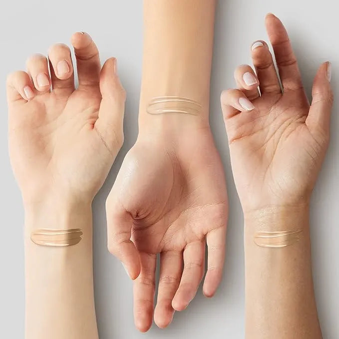 Three hands with different skin tones showing a small amount of makeup on wrists.